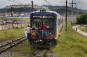 Jovens viajam pendurados do lado de fora de trem da CPTM