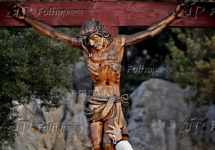 FILE PHOTO: A woman touches a crucifix at the site where the Virgin Mary reportedly appeared in an apparition in Medjugorje