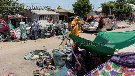 People take refuge along an expressway after relief camps reached maximum capacity in Maiduguri