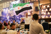 People gather on Christmas day at a restaurant in Damascus