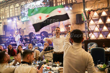 People gather on Christmas day at a restaurant in Damascus