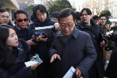 Seok Dong-hyeon, a lawyer for South Korea's impeached President Yoon Suk Yeol, is surrounded by media upon his arrival at a court, in Seoul