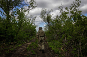 A Ukrainian serviceman of the 22nd Separate Mechanized Brigade walks near an artillery position on the outskirts of Chasiv Yar