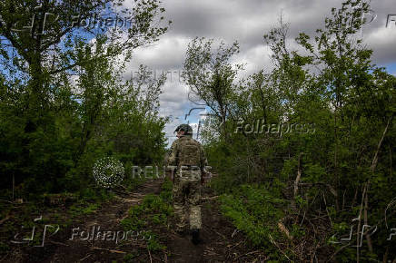A Ukrainian serviceman of the 22nd Separate Mechanized Brigade walks near an artillery position on the outskirts of Chasiv Yar