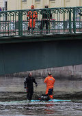 Rescuers work at the site where a bus fell into a river in Saint Petersburg