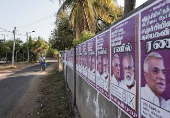 A man rides a bicycle next to the election campaign posters of Eelam People's Democratic Party in Jaffna