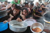 Palestinians gather to receive food cooked by a charity kitchen, amid the Israel-Hamas conflict, in the northern Gaza Strip