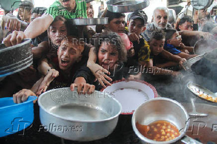 Palestinians gather to receive food cooked by a charity kitchen, amid the Israel-Hamas conflict, in the northern Gaza Strip