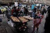 People walk past a street vendor's stall in downtown of Damascus