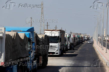 Trucks carrying aid line up near the Rafah border crossing between Egypt and the Gaza Strip, in Rafah