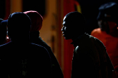 Migrants wait to disembark from a Spanish coast guard vessel, at the port of Arguineguin, on the island of Gran Canaria