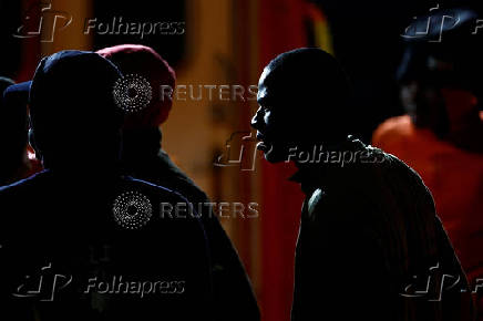 Migrants wait to disembark from a Spanish coast guard vessel, at the port of Arguineguin, on the island of Gran Canaria