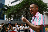 Transgender activist Henry Tse, who won the appeal to change the gender on his ID card, poses outside the immigration office after receiving his new ID card in Hong Kong