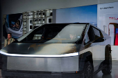 A person sits inside a Tesla Cybertruck at a Tesla showroom in New York City