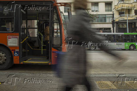 Pedestre passa em frente a nibus na rua Xavier de Toledo, no centro de SP
