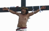 Catholic penitent nailed to cross on Good Friday in Holy Week of Lent
