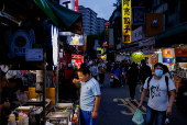 A boy eats at a night market in Taipei