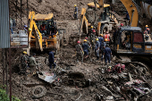 Rescue personnel work to retrieve the bodies of victims from a landslide triggered by heavy rainfall at the Tribhuwan Highway in Dhading