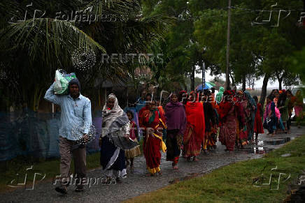 People evacuate their village during a mock drill to prepare against tsunami, ahead of the 20th anniversary of the Indian Ocean tsunami, in Kaitha village