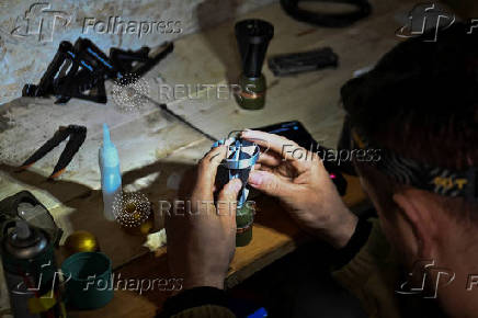 Policeman of the 'Khyzhak' Brigade makes a miniature drop bomb a drone at a position in a front line near the town of Toretsk