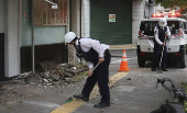 Police officers try to remove debris caused by an earthquake in Uwajima, Ehime prefecture, western Japan