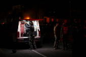 Israeli police bomb squad members work near a damaged site after a projectile fired from Yemen was intercepted, in Ramat Gan