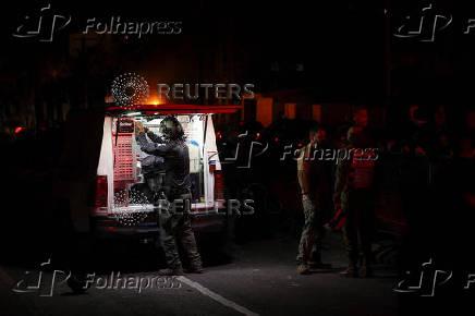 Israeli police bomb squad members work near a damaged site after a projectile fired from Yemen was intercepted, in Ramat Gan