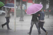Pedestres se protegem da chuva em Campinas (SP)