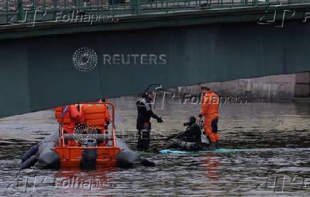 Rescuers work at the site where a bus fell into a river in Saint Petersburg