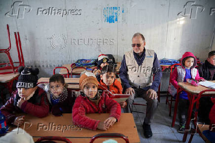 UNICEF Deputy Executive Director, Ted Chaiban, sits with children inside a portable classroom during his visit to a damaged school in Aleppo