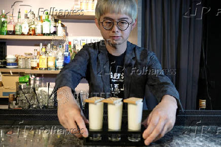 Powei Lee, 31, owner of Kinmen Mojo Bar (or Vent Bar), displays for the camera the 