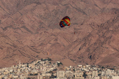 A person uses a parachute as the Jordanian city of Aqaba is seen in the background, in Eilat
