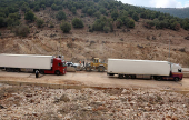 Trucks drive through the Masnaa border crossing between Lebanon and Syria