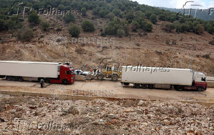 Trucks drive through the Masnaa border crossing between Lebanon and Syria