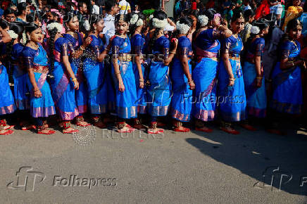 Participants wearing colourful attire, stand in the queue to enter inside the Jawaharlal Nehru International Stadium to perform Bharatanatyam dance, in Kochi