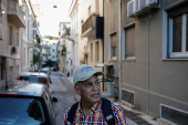 A tourist looks on at the neighbourhood of Koukaki, in Athens