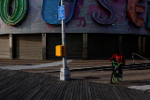 A boy rides a bicycle on the boardwalk of at Coney Island  in the Brooklyn borough of New York City