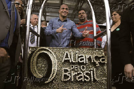 Apoiadores de sigla criada por Bolsonaro posam com pea com o logotipo do partido