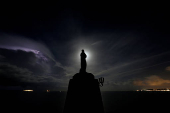 FILE PHOTO: A statue of the Madonna overlooks the sea as the  supermoon rises and a lightning storm strikes off the coast at Marfa Ridge, in the north of Malta,