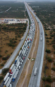 Trucks wait in line to cross into the United States, at the World Trade Bridge