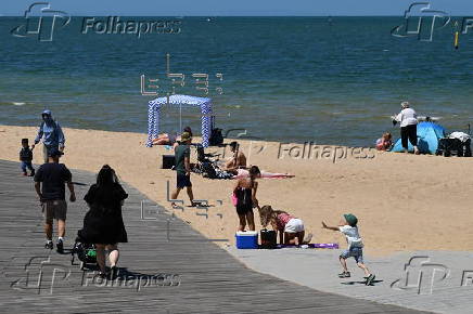 People relax on Melbourne St Kilda beach