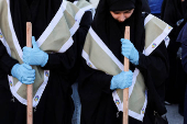 Members of Imam al-Mahdi scouts clean rubble and debris from damaged buildings in Beirut's southern suburbs