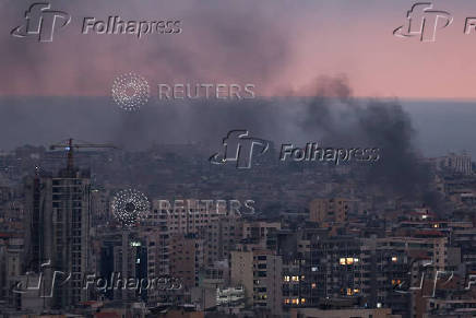 Smoke rises in Beirut's southern suburbs during sunset, after Israeli air strikes, amid ongoing hostilities between Hezbollah and Israeli forces, as seen from Sin El Fil