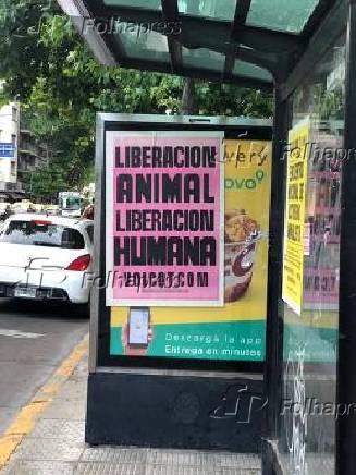 Cartaz colado em cima de propaganda de fast-food de frango em Buenos Aires