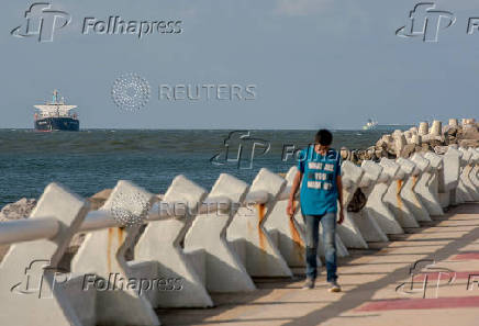 FILE PHOTO: A man walks as a Bright Fortune crude oil tanker floats near Pemex's Pajarito terminal in the city of Coatzacoalcos