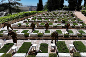 Israeli soldiers place Israeli flags on the graves of fallen soldiers, ahead of Israel's Memorial Day due to begin next week, at Mount Herzl military cemetery in Jerusalem