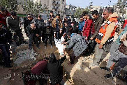 Mourners bury the body of a Palestinian killed in an Israeli airstrike, at Nuseirat refugee camp