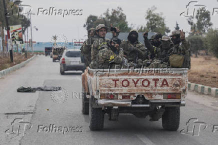 Rebel fighters sit on a vehicle in Homs countryside