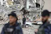 Palestinian Hamas policemen keep guard at their destroyed headquarters in Gaza City