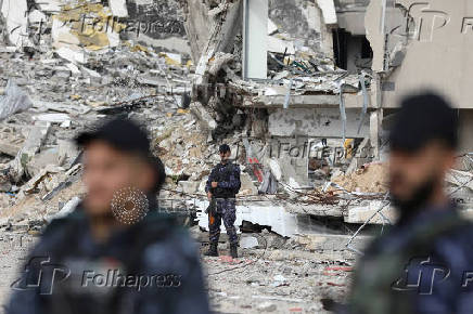 Palestinian Hamas policemen keep guard at their destroyed headquarters in Gaza City